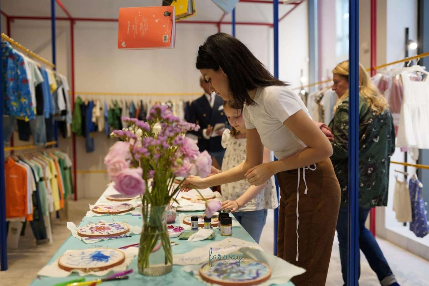 Il tavolo del workshop Farway Milano con Minimodes allestito nello store, con telai da ricamo, colori e fiori
