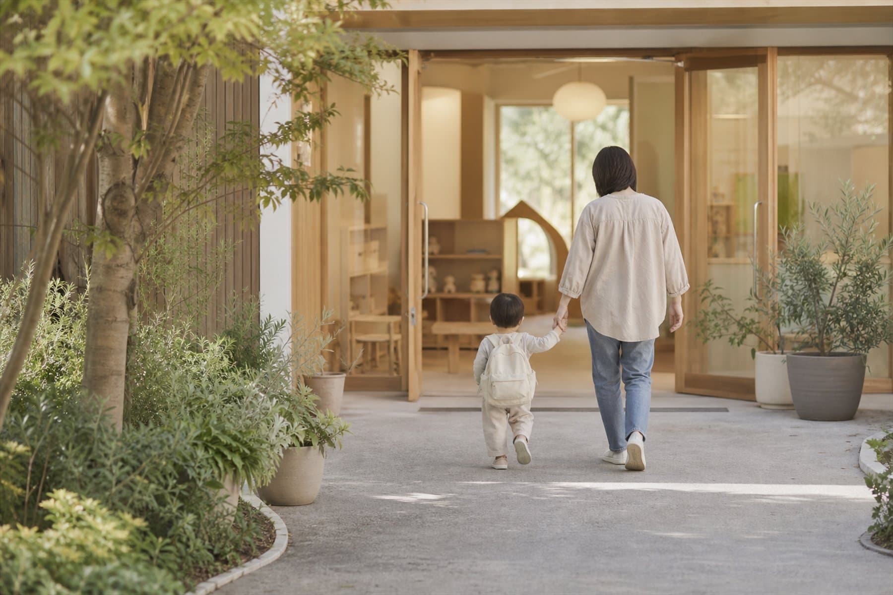 Genitore accompagna il bambino per mano all'ingresso del nido