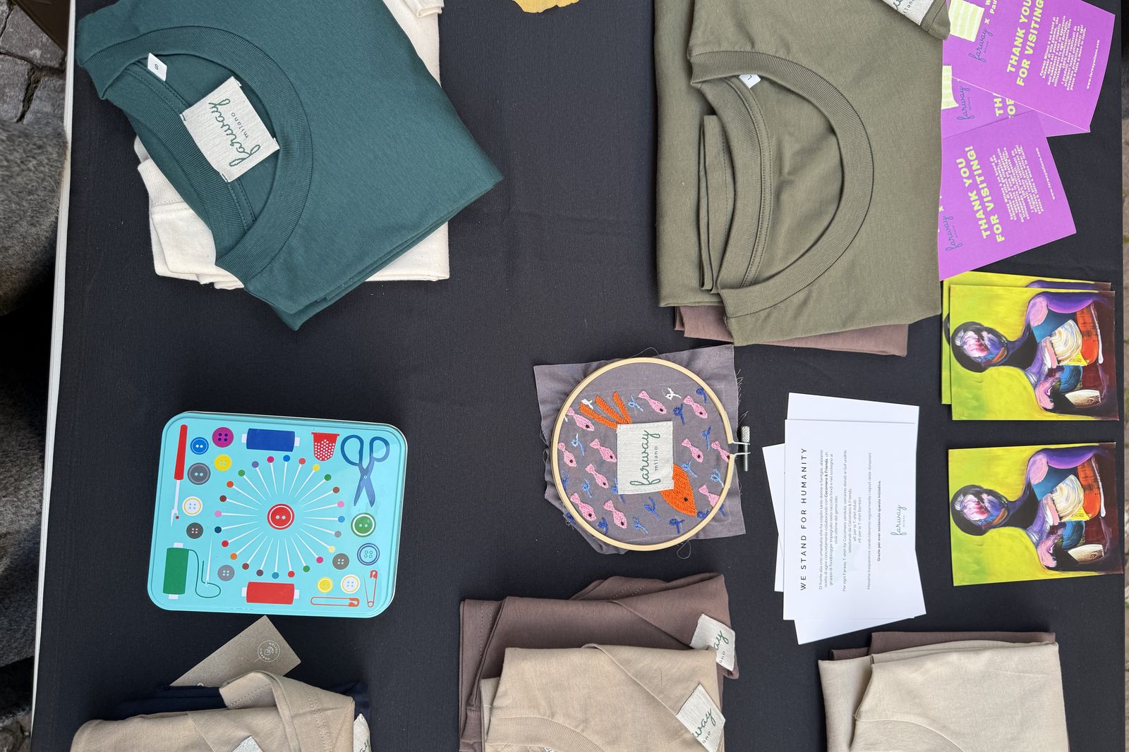 Il tavolo del laboratorio Little Couture Atelier con t-shirt in cotone organico Farway Milano, telaio da ricamo e materiali creativi